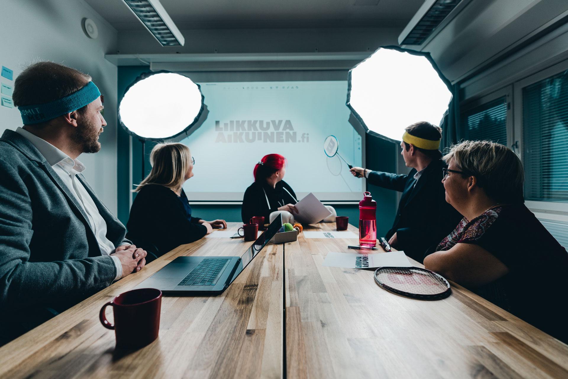 Five persons sitting at a conference table.