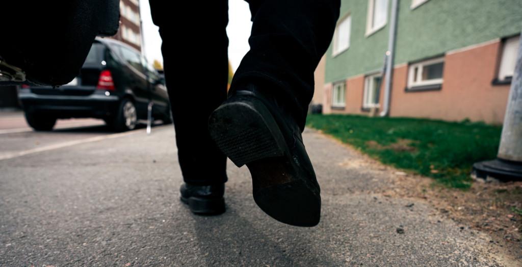 A man's feet walking down the street