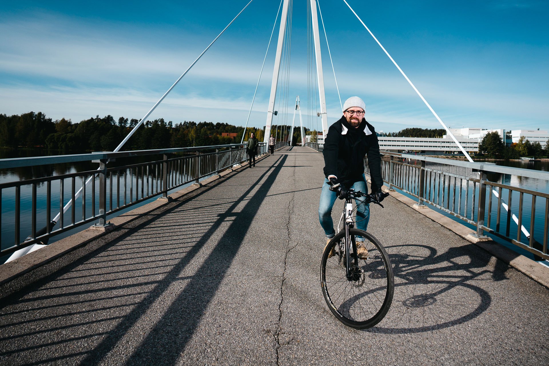 Kuvassa mies pyöräilee kevyen liikenteen sillalla.